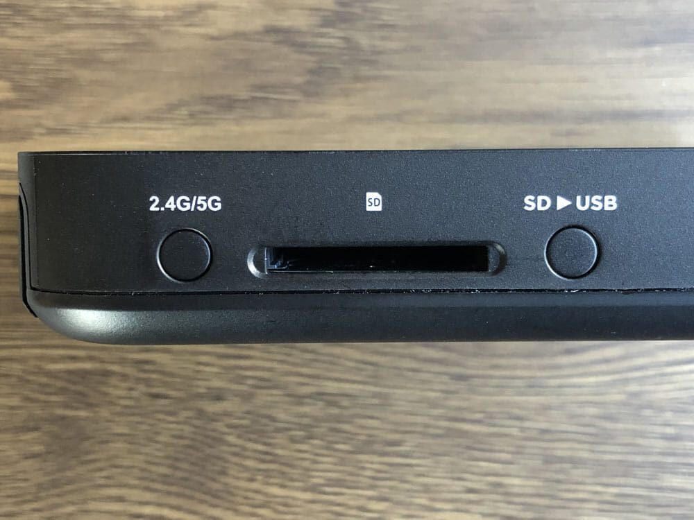 【RAVPower Filehub RP-WD009レビュー】スマホ写真＆動画データを簡単バックアップ！無線でデータ共有もできるWi-Fi SDカードリーダー｜旅行などに最適｜外観：左側面には周波数を切り替えるボタン、SDカードスロット、SDカードからUSBにバックアップを行うためのボタンが配されています。
